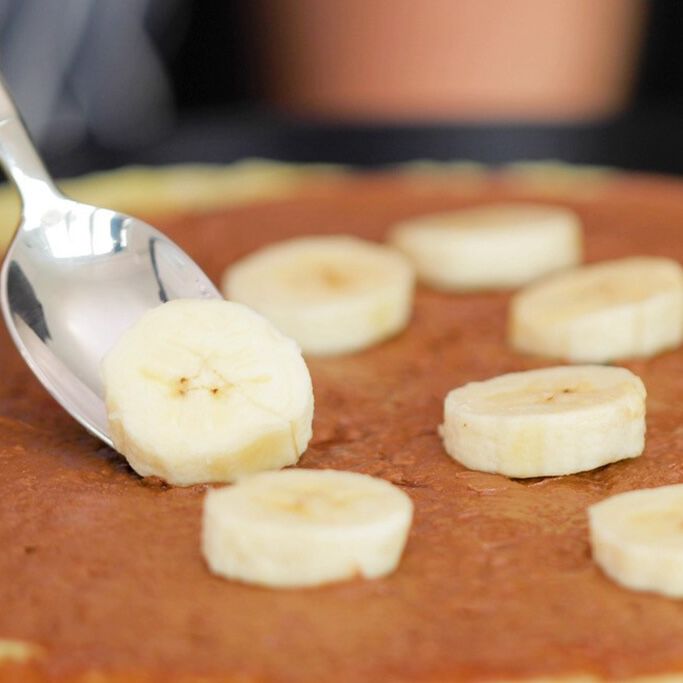 Hazelnut spread crepe with spoon placing bananas
